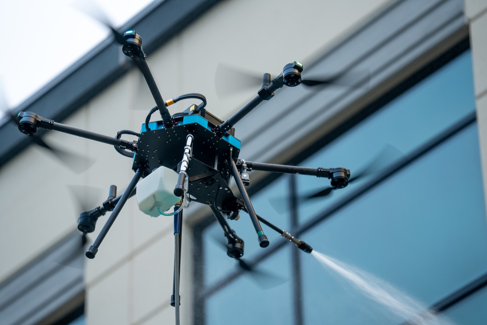 SkyWash Coastal drone washing the windows of a multi-story building